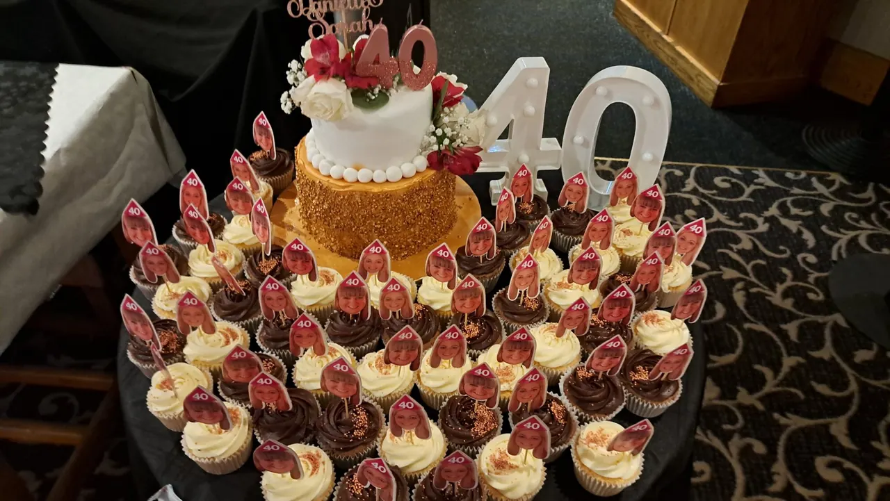 40th birthday cake surrounded by decorated cupcakes